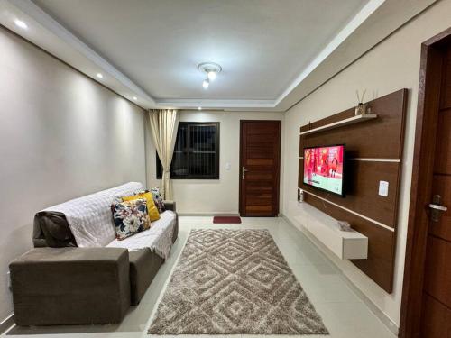 a living room with a couch and a flat screen tv at Duplex Central Rio Grande in Rio Grande
