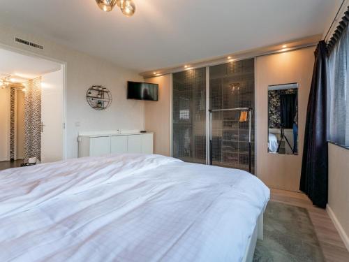 a bedroom with a large white bed and a television at Alkmaar aan het Water in Alkmaar