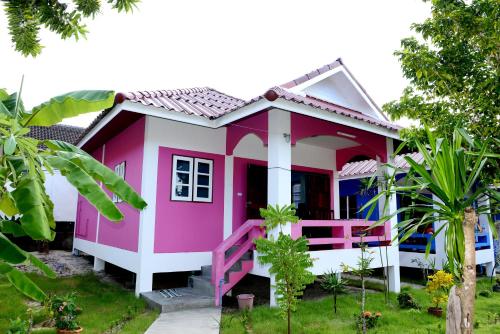 a pink and white house with a porch at New Sunrise Village in Mae Nam