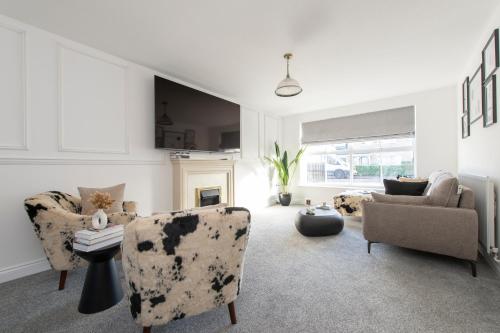 a living room with two chairs and a couch at Stunning 5 bedroom detached house in Hornchurch in Romford