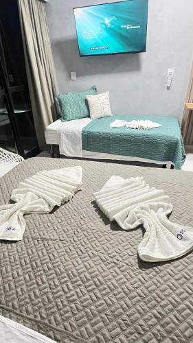 two beds in a room with towels on the floor at Makia beach experience 315A Kay in Porto De Galinhas