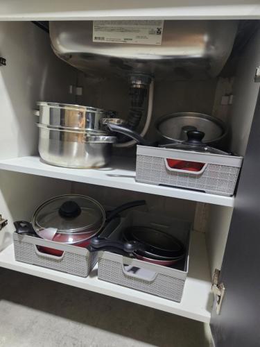 a shelf with pots and pans in a kitchen at Sobrado novo e lindo com piscina in São José dos Campos