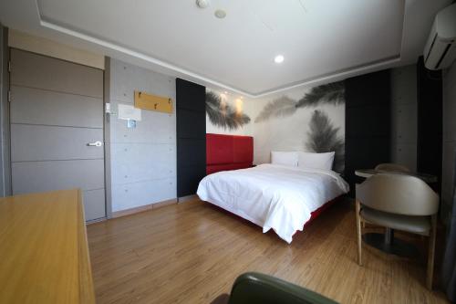 a bedroom with a bed and a desk and a chair at Hotel memory Jumunjin- Welcome drink provided in Gangneung