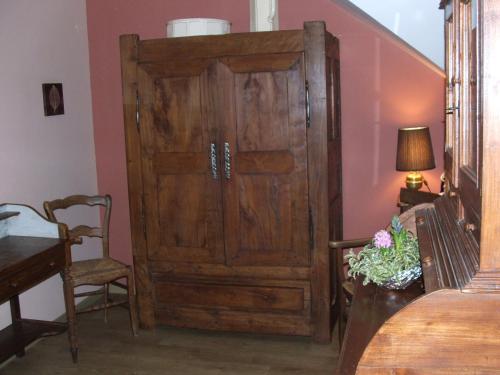 a large wooden cabinet in a room with a table at Gîte de Guernevez in Hôpital-Camfrout