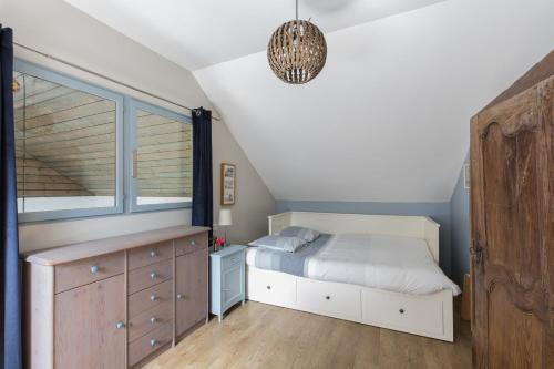 a bedroom with a bed and a dresser and a window at Gîte de Guernevez in Hôpital-Camfrout