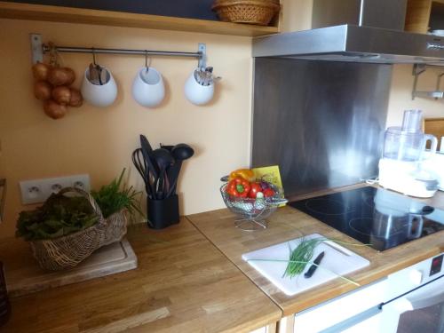 a kitchen with a counter with utensils on the wall at Gîte de Guernevez in Hôpital-Camfrout