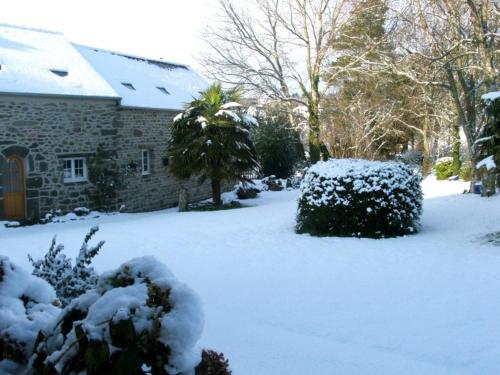 a yard covered in snow in front of a house at Gîte de Guernevez in Hôpital-Camfrout