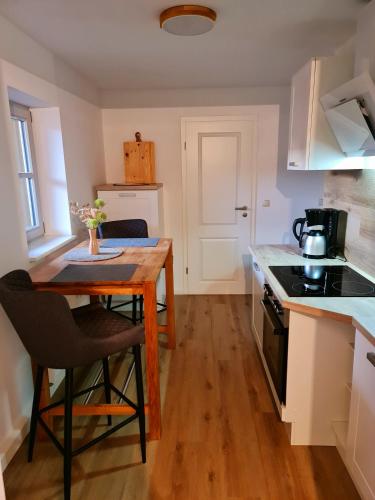 a small kitchen with a wooden table and a stove at Apartments Herzberg in Kaxdorf