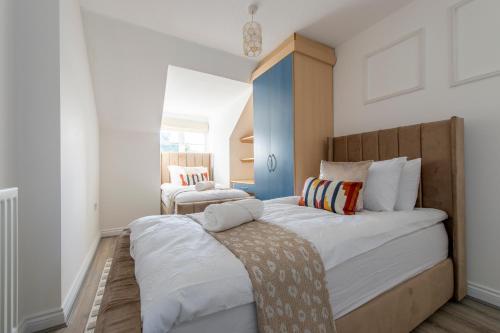 ein Schlafzimmer mit zwei Betten mit weißen Wänden in der Unterkunft Stunning 5 bedroom detached house in Hornchurch in Romford