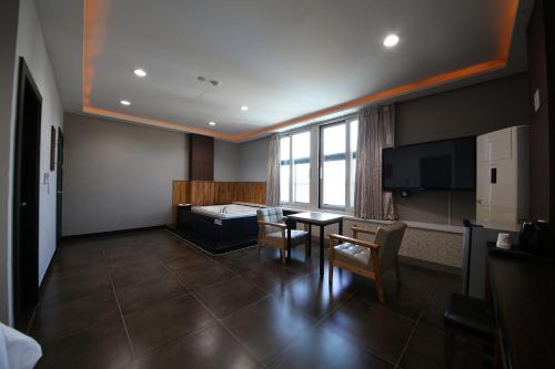 a waiting room with a table and chairs and a television at Hotel memory Jumunjin- Welcome drink provided in Gangneung