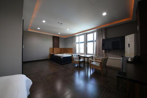 a hotel room with a bed and a table and a television at Hotel memory Jumunjin- Welcome drink provided in Gangneung