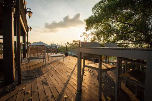 a deck with benches and a table on a building at Bangkok Tree House Bang Kachao in Bangkok