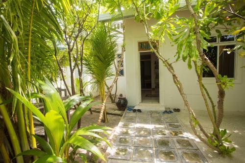 a house with a courtyard with palm trees at Faza View Inn, Maafushi in Maafushi