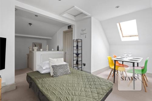a bedroom with a bed and a table and chairs at Cosy apartment in Moulsham, Long Stays Welcome in Chelmsford