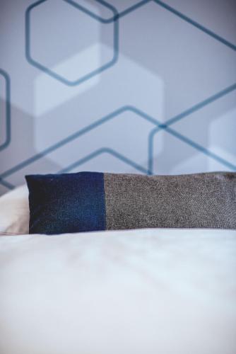 a black and blue tie sitting on top of a bed at arte Hotel Kufstein in Kufstein