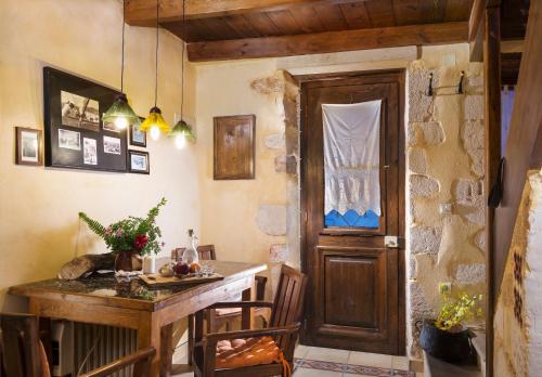 Habitación con mesa y puerta de madera. en Villa Margot, en La Canea