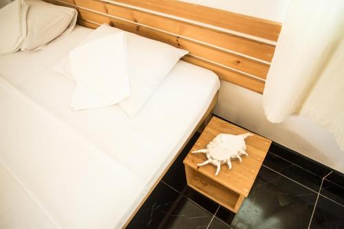 a small bed in a room with a table at Faza View Inn, Maafushi in Maafushi