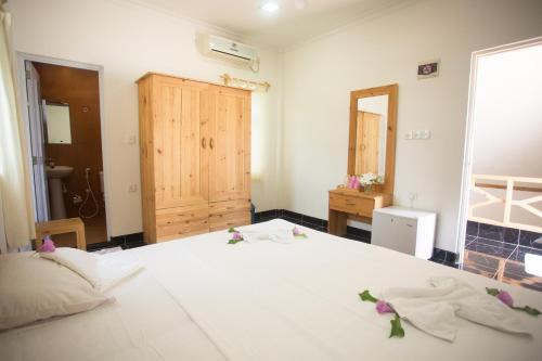 a bedroom with a large white bed with flowers on it at Faza View Inn, Maafushi in Maafushi