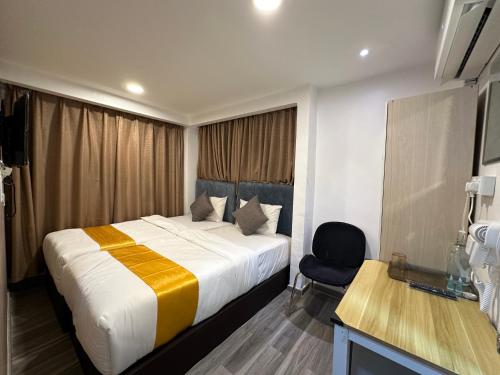 a hotel room with a bed and a chair at SS Grey Hotel Bukit Bintang in Kuala Lumpur