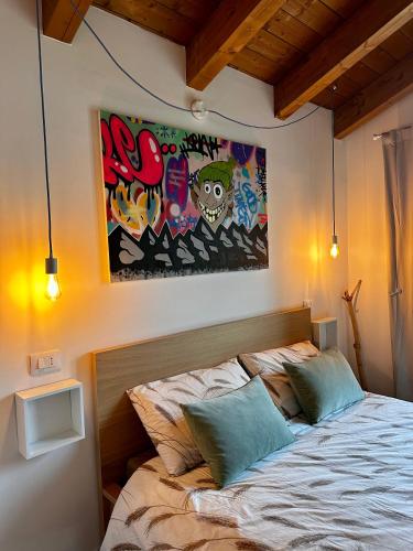 a bedroom with a bed with a painting on the wall at Jazz Shelter! Relax tra le vette abruzzesi! in Ovindoli