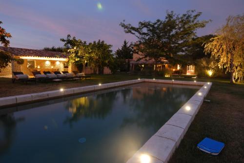 - une piscine dans la cour d'une maison la nuit dans l'établissement Clos De La Fontaine, à Cabrières-dʼAvignon