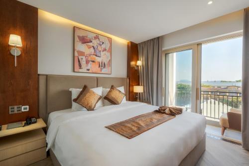 a bedroom with a large bed and a large window at Ngon Avatar Hotel in Pleiku