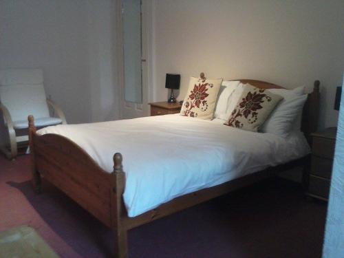 a bedroom with a bed with white sheets and pillows at Lochgair Hotel in Lochgair