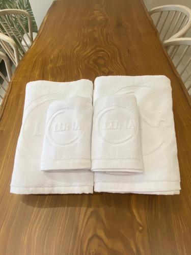 two white towels sitting on top of a wooden table at 大溪漁港蜜月灣Luna民宿2號館 in Toucheng