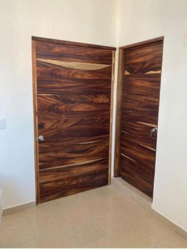 a wooden closet with two wooden doors in a room at Apartment 3 Maleconcito del Sol Barra de Navidad in Barra de Navidad