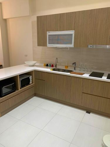 a kitchen with a sink and a microwave at 大溪漁港蜜月灣Luna民宿2號館 in Toucheng
