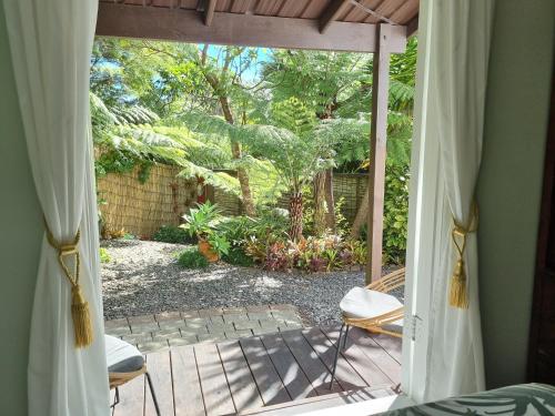 a sliding glass door to a patio with a yard at Coromandel Eco Sanctuary in Coromandel Town