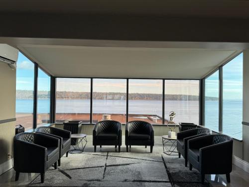a room with chairs and tables and large windows at Anchor Inn and Suites in Campbell River