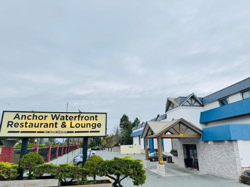 a sign for a restaurant and lounge in front of a building at Anchor Inn and Suites in Campbell River