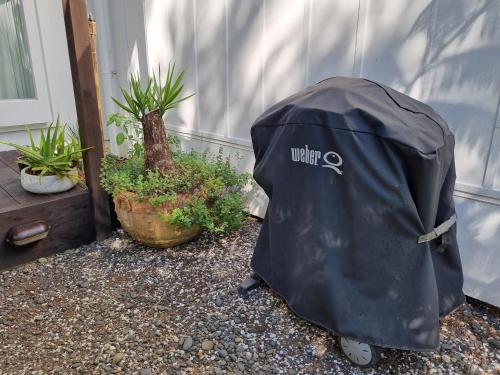 a black backpack sitting in front of a house at Coromandel Eco Sanctuary in Coromandel Town