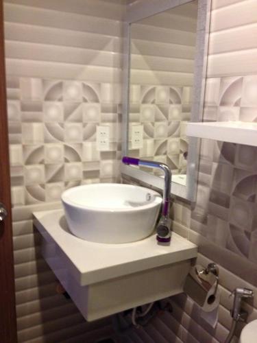 a white sink in a bathroom with a mirror at Nha Trang Seaview Penthouse Apartment in Nha Trang