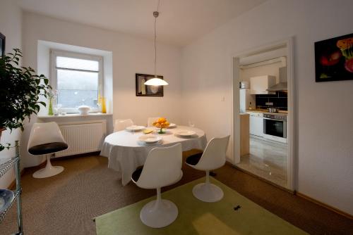 ein Wohnzimmer mit einem weißen Tisch und Stühlen in der Unterkunft Atelier Valwig in Valwig