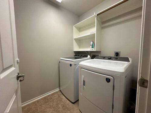 a small white laundry room with a washer and dryer at Cozy townhome in The Woodlands in The Woodlands