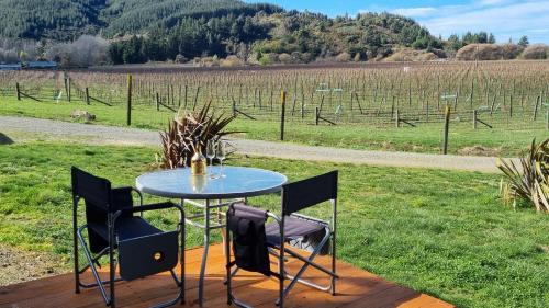 a table and chairs with a view of a field at Caravino - Above the Vines in Waikakaho