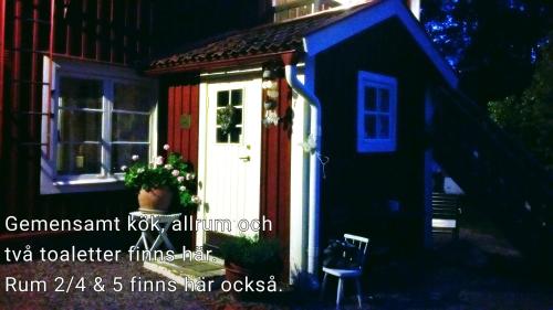 a small house with a red and white door at Stora Djulö Vandrarhem in Katrineholm