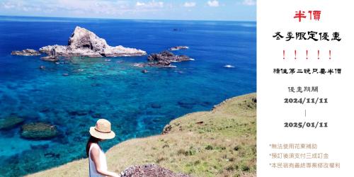 Una mujer parada en un acantilado mirando el océano en Beer Inn綠島, en Isla Verde