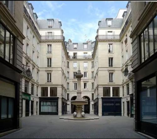 un grand bâtiment avec une fontaine devant lui dans l'établissement Room S - Louvre Museum - shared bathroom with host, à Paris