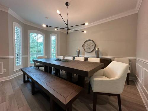 a dining room with a table and chairs and a clock at Luxury Home in The Woodlands in The Woodlands