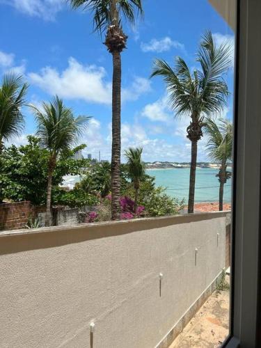 a view of a beach with palm trees and the ocean at Apartamento Morro do Careca in Natal