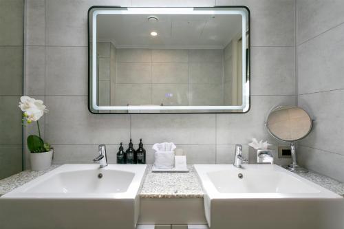 a bathroom with two sinks and a mirror at Sacred Waters Taupo in Taupo