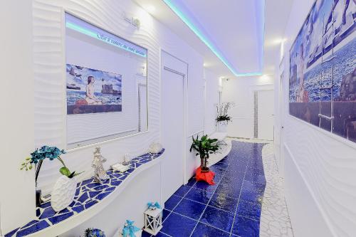 a bathroom with a blue tile floor and a large screen at La Madegra Seasuite in Salerno