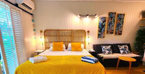a bedroom with a large bed and a yellow blanket at Deluxe Private Apartment- In Ramada Resort - Full Kitchen - in Port Douglas