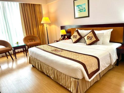 a bedroom with a large bed in a hotel room at Mondial Hotel Hue in Hue