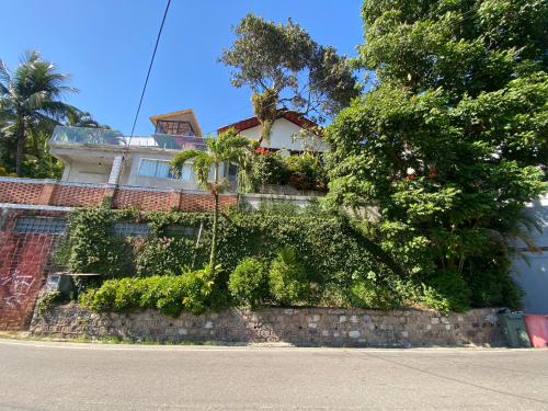 a building with plants on a wall next to a street at Casa da Vovó - Barra Guaratiba in Rio de Janeiro