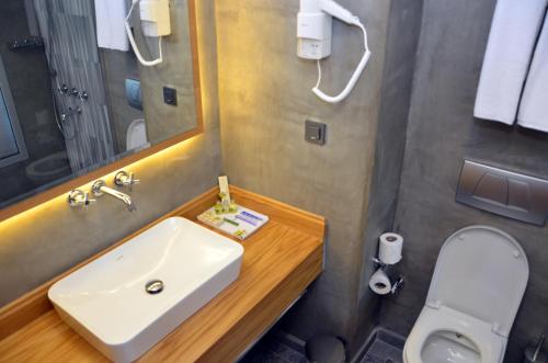 
a bathroom with a sink, toilet, and shower stall at Bacacan Otel in Ayvalık

