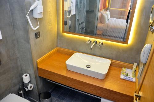 ein Bad mit einem Waschbecken und einem Spiegel in der Unterkunft Bacacan Otel in Ayvalık